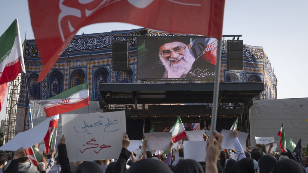 Manifestantes iranianos sob um retrato do líder supremo Ayatollah Ali Khamenei durante um protesto em Teerão para condenar os ataques dos EUA, 22 de junho de 2025. Morteza Nikoubazl/NurPhoto / Gettyimages.ru